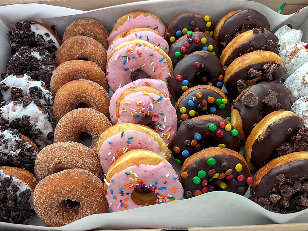 Tray of assorted frosted and sprinkled donuts